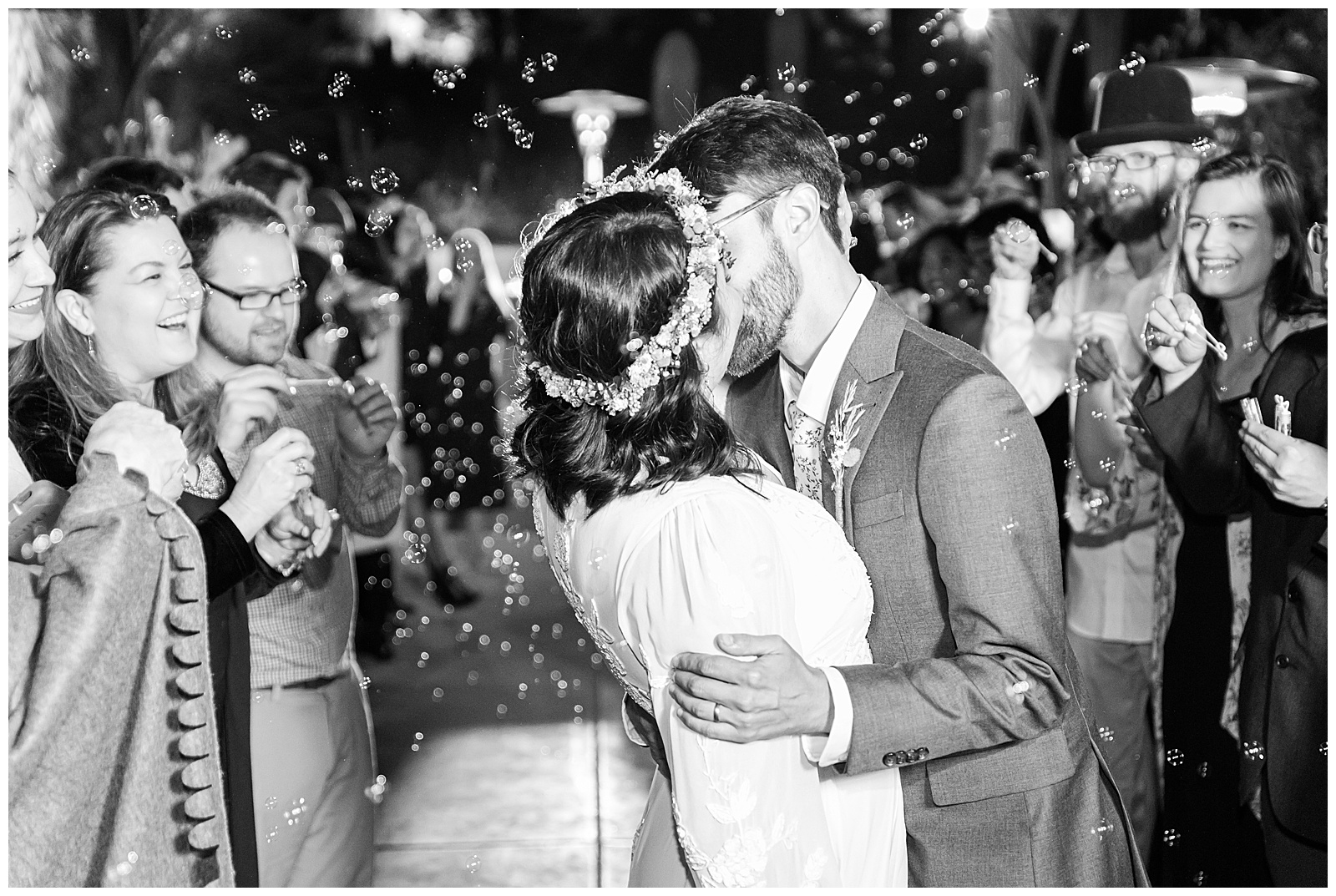 Husband and wife kissing in a swarm of bubbles.