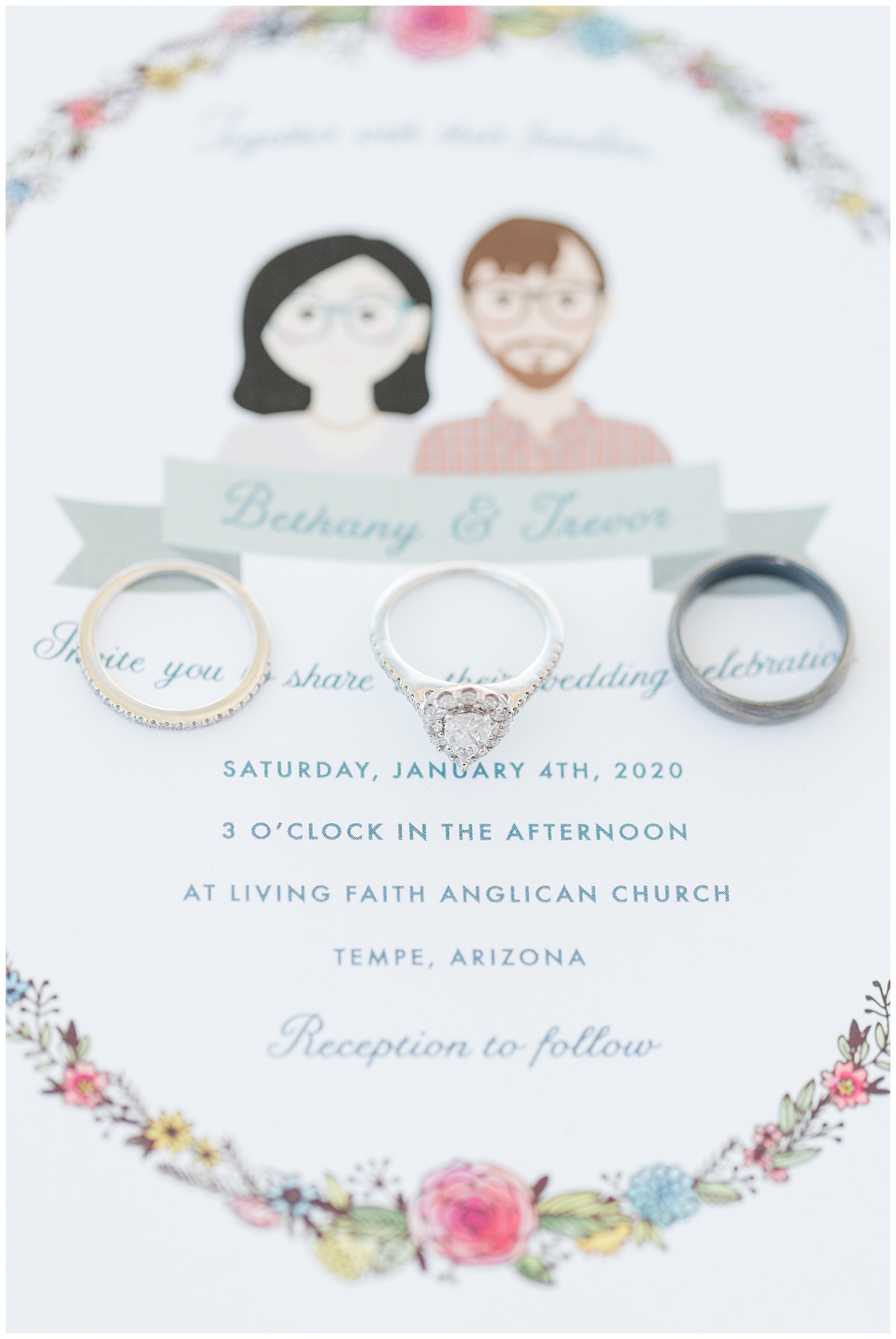 Phoenix wedding photographer shows wedding rings atop an invitation.