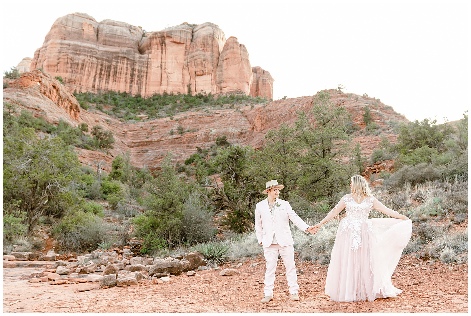 Married couple holds hands in front of Cathedral Rock
