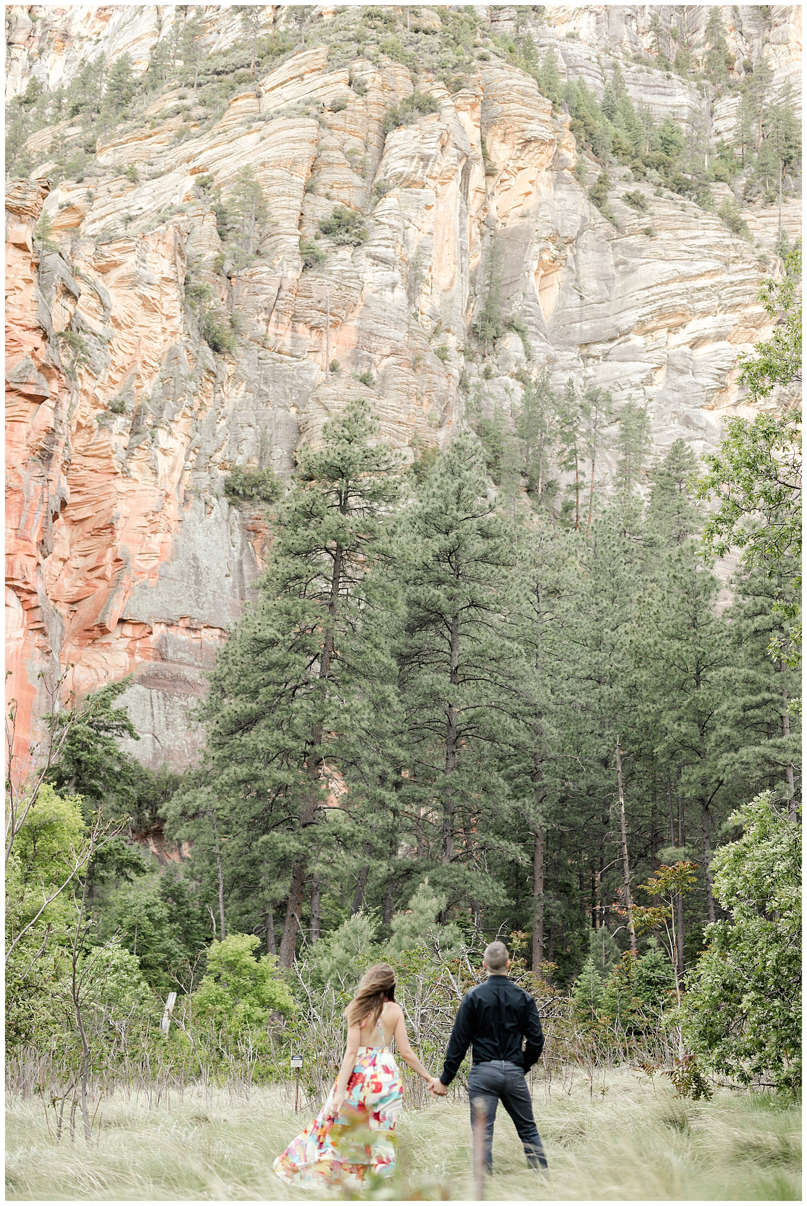 engagement photographer couple looking up at epic mountain 