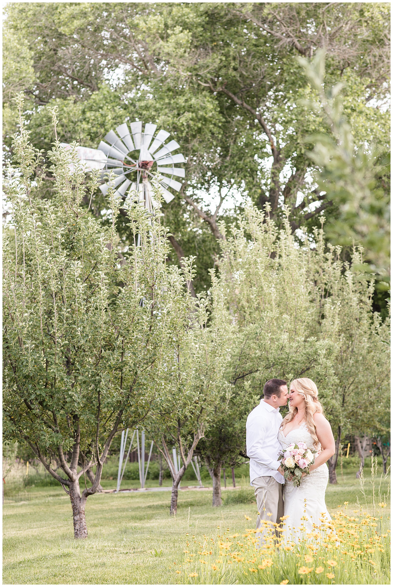 Bride and groom kiss in front of a windmill in Sedona