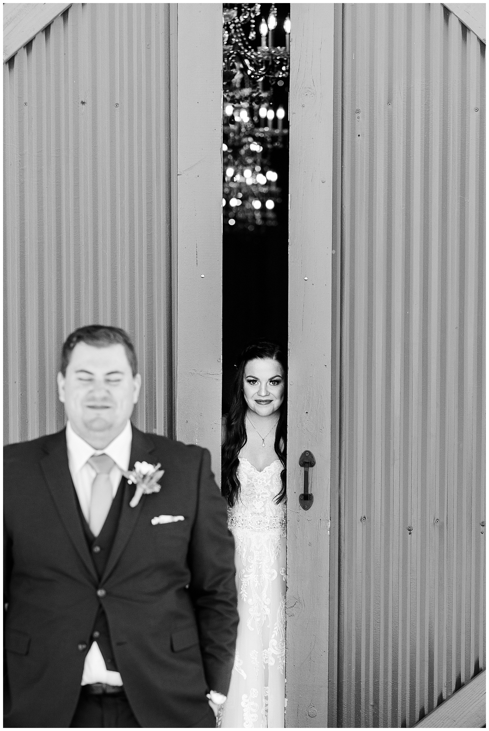 Bride peeking through barn doors during their wedding first look